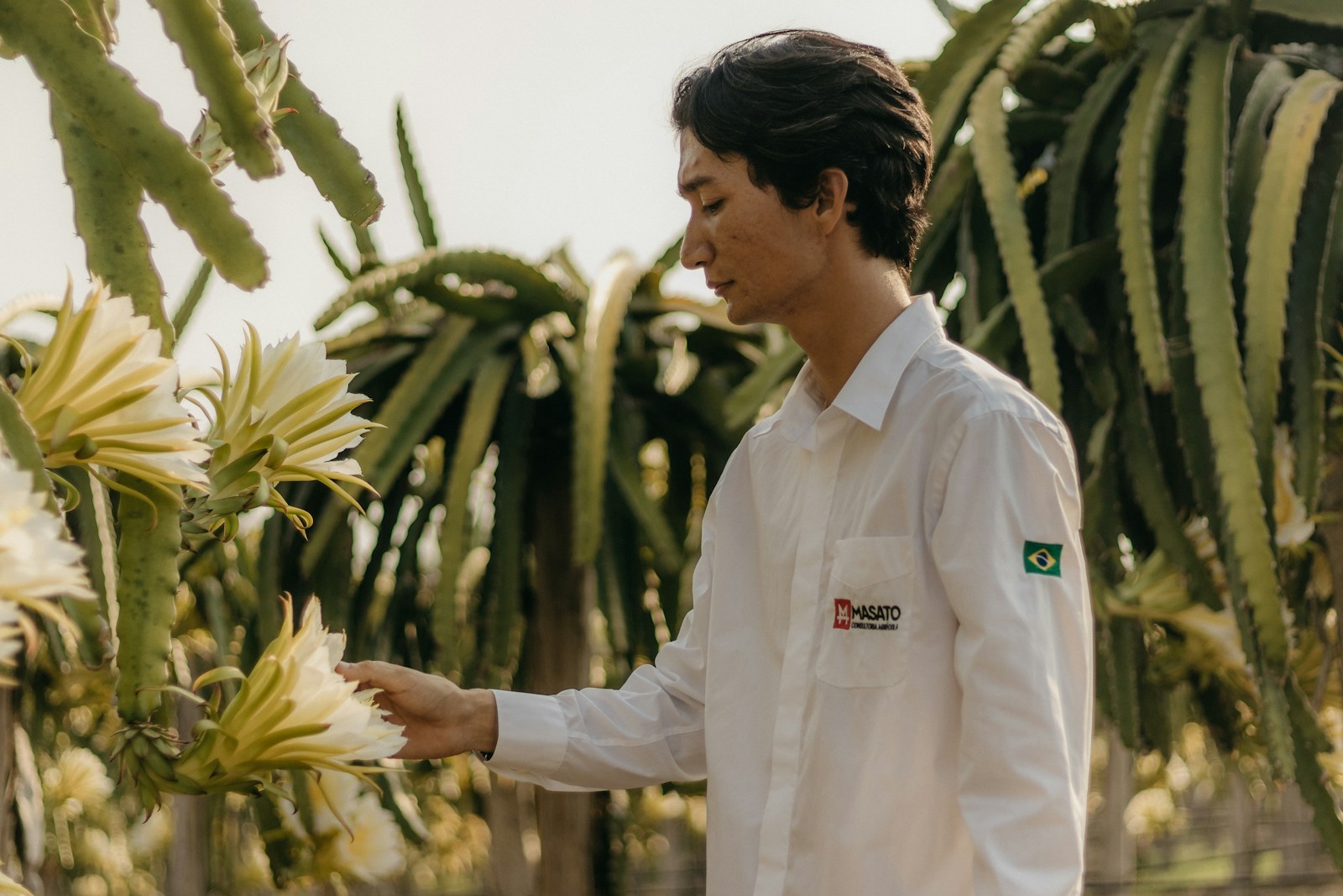 Photo by Kawê Rodrigues a man standing next to a bunch of flowers